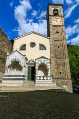 Fototapeta na wymiar DERVIO, ITALY - APRIL 30th 2018: old Parrocchia Prepositurale Ss.Pietro E Paolo church standing in the center of the Italian village Dervio by the Como lake, lit by the spring sun.