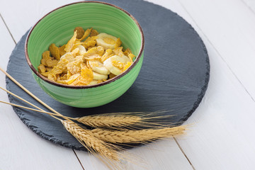 Zum Frühstück essen Müsli, Banane und Cornflakes