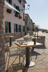 Cozy outdoor cafe at Burano island in Venice, Italy