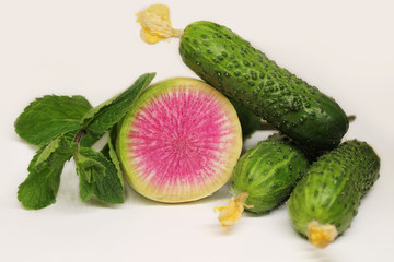 A lot of cucumbers in the basket. Cucumbers in a large wicker basket. Vegetables in wicker vessels for diet. A lot of cucumbers in a wicker box. Sliced cucumbers on a cutting board.