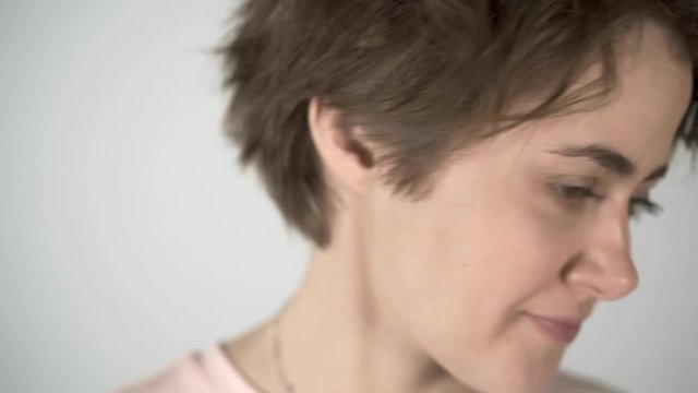 Portrait of a young woman with short brown hair, big eyes and full lips saying a definite no to someone off camera. Locked down real time medium shot