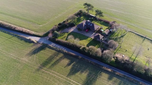 Aerial footage residential real estate panning down showing the single-family detached house property beautiful rural environment green field surrounding the property footage shot during summer day 4k