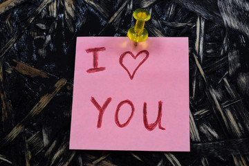 inscription I love you on a pink sheet of paper