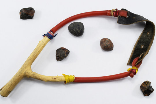 Slingshot and stones for shooting from it on a white background
