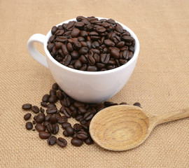 Cup and coffee beans on burlap background