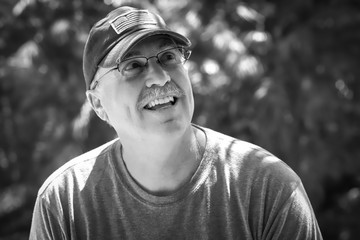 Senior male looks up during outdoor conversation in black and white