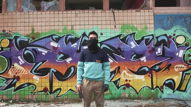 Portrait of young man graffiti artist on graffiti wall background