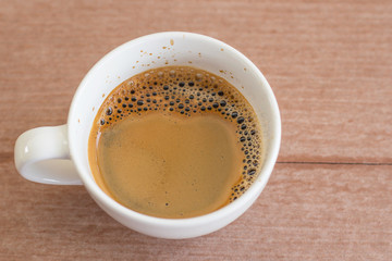 Cup of fresh coffee on wooden background, top view