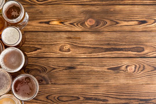 Frothy pints of beer on timber bar with copy space