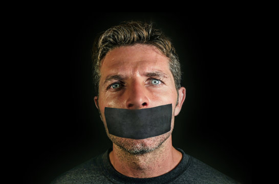 Young Man With Mouth And Lips Sealed Covered With Adhesive Tape In Censorship Coerced Freedom Of Speech And Forced Silence And Secrecy