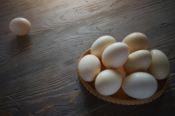 A pile of chicken eggs on an old wooden table