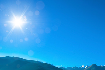 Fototapeta na wymiar Blue sky with sunny sun and mountain.