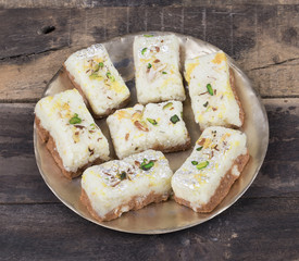 Indian Diwali Sweet Food Kalakand Also Know as Halwa or Mawa Kalakand is a Creamy Delicacy Made From Paneer or Cottage Cheese, The Dish Originated in Alwar, Rajasthan. Kalakand on Wooden Background