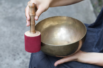 Big Tibetan singing bowl in the hands of a woman.