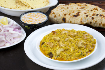 Indian Traditional Vegetarian Cuisine Kaju Curry Also Called Kaju Butter Masala Served with Tandoori Roti, Raita, Salad And Papad