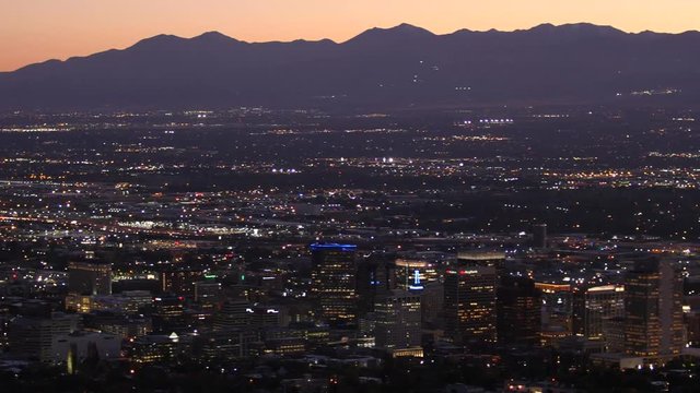 Lights shine in the Salt Lake City skyline at dusk.