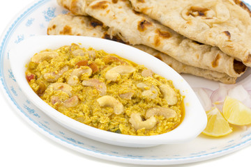 Indian Traditional Vegetarian Cuisine Kaju Curry Also Called Kaju Butter Masala Served With Tandoori Roti And Salad isolated on White Background
