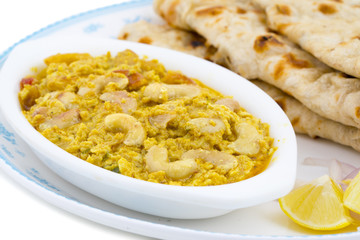 Indian Traditional Vegetarian Cuisine Kaju Curry Also Called Kaju Butter Masala Served With Tandoori Roti And Salad isolated on White Background