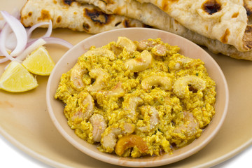 Indian Traditional Vegetarian Cuisine Kaju Curry Also Called Kaju Butter Masala Served With Tandoori Roti And Salad isolated on White Background