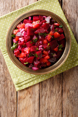 Moroccan beetroot salad with onions, tomatoes and herbs close-up.Vertical top view from above