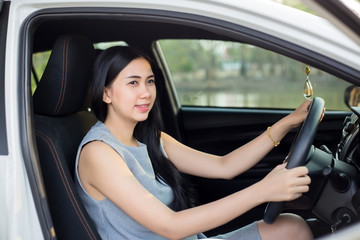 Obraz na płótnie Canvas Pretty Asian women in a white car happy driving