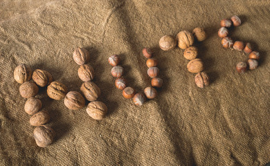 Inscription nuts made from walnut and hazelnut on the sacking background