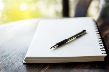 notebook and pen on a wooden table