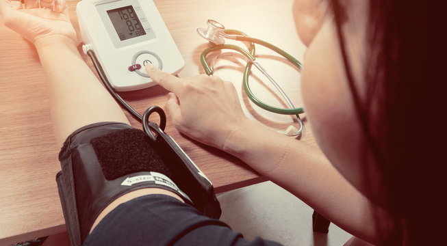 Woman Measuring Arterial Blood Pressure By Her Self, Controlling Blood Pressure, Hospital And Medicine Concept