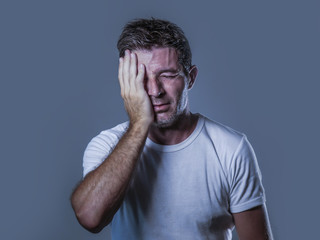 portrait of sad and depressed man with hand on face looking desperate feeling frustrated and...