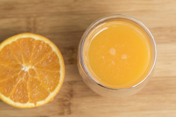 Orange juice served with and orange slice isolated on a wooden surface plate
