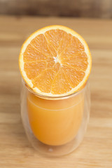 Orange juice served with and orange slice isolated on a wooden surface plate
