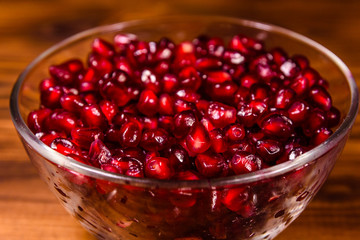 Seeds of the garnet fruit in glass bowl on wooden table