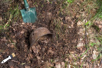 Fototapeta premium Excavations in the forest. The German helmet. Imitation. WW2 recovery. Russia.