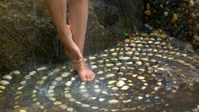 A beautiful girl takes a shower outside.