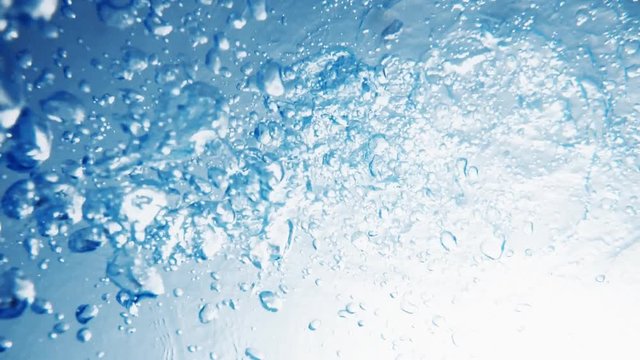 Air bubbles rising up to surface in blue pure ocean. Sunshine penetrating crystal clear sea water. Person drowning.