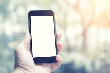 Unrecognizable people hand holding mobile phone and blank white screen for your advertisment or promotional text. Communication and technology background  concept.