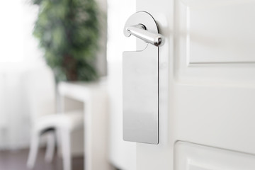 Door knob with empty label on a door handle for your text. Empty white flyer mockup hang on door...