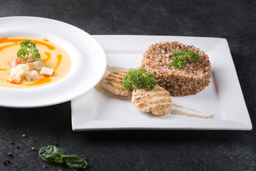 Complex dinner. Buckwheat porridge with dietary meat on a white plate is tenderly served