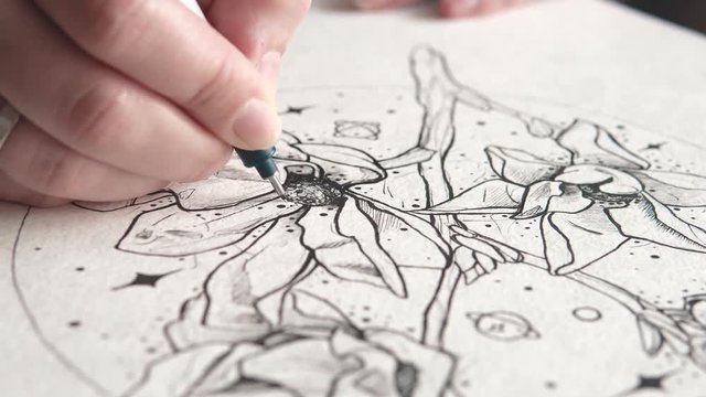 tattoo master makes a sketch of tattoo on paper