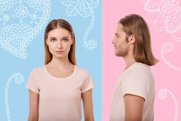 Working models. Young qualified model looking at young while standing near her experienced colleague and posing in similar casual clothes