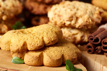 Christmas concept with assortment of cookies and decorations on a log over wooden background, selective focus