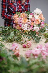 Female florist. Floral workshop - woman making a beautiful flower composition a bouquet. Floristry concept