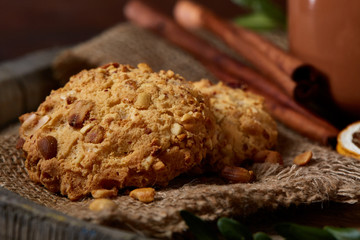 Conceptual composition with a couple of cookies and cinnamon on a wooden barrel, selective focus, close-up