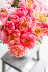 Lovely flowers in glass vase. Beautiful bouquet of peonies sort of coral charm. Floral composition, scene, daylight. Wallpaper. Vertical photo