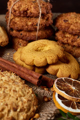 Conceptual composition with assortment of cookies and cinnamon on a wooden barrel, selective focus, close-up