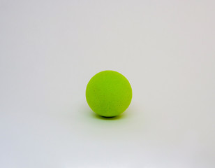 A bright green toy ball, place for text, close-up, isolated