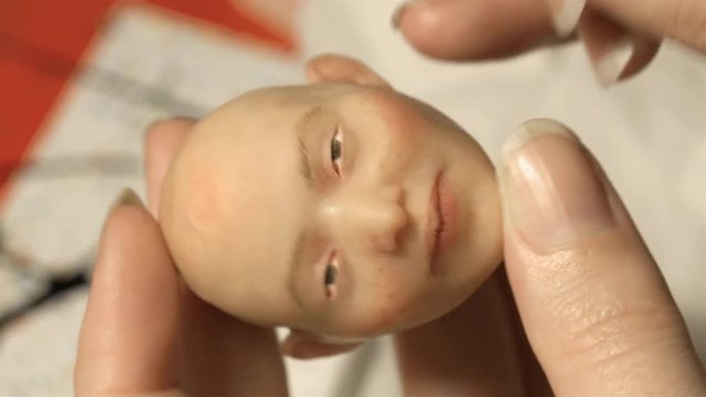Painting a hand made puppet head by hand