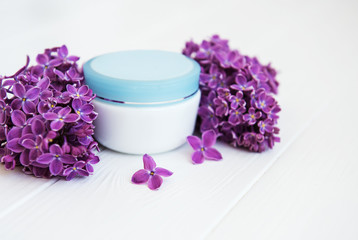 Obraz na płótnie Canvas lilac flowers and cosmetic cream