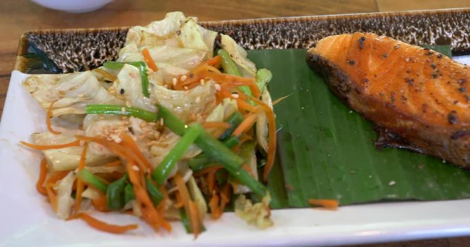 Thai vegetable salad with shredded carrots and cabbage served on a banana leaf