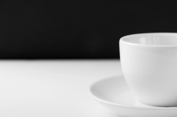 White mug for tea on a white wooden table on a black background.